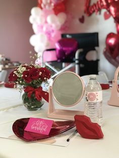 the table is set up for a valentine's day party with balloons and flowers