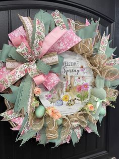 a welcome spring wreath with flowers and ribbons on the front door for someone to welcome