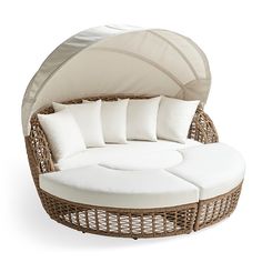 a wicker day bed with white cushions