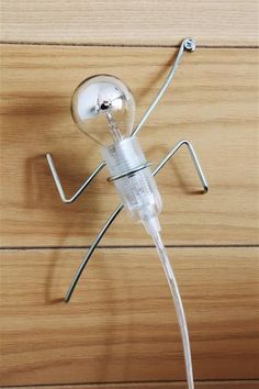 a lightbulb is attached to a wooden surface with metal wires and plugs