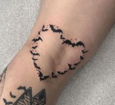 a person with a tattoo on their arm that has bats in the shape of a heart