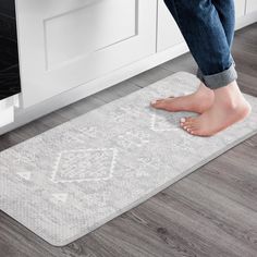 a person standing on the floor in front of an oven with their feet propped up