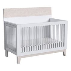 a white crib with a wooden headboard and foot board on the bottom half