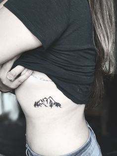 a woman with a mountain tattoo on her stomach