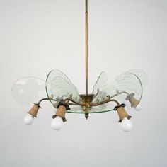 a glass and brass chandelier with five lights hanging from it's sides