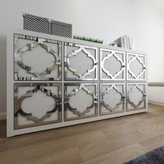 the sideboard is made out of mirrored panels and has an intricate design on it