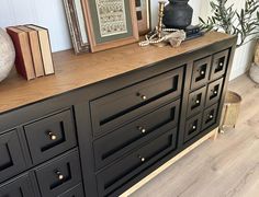 a black dresser with gold handles and knobs in a room next to a wall