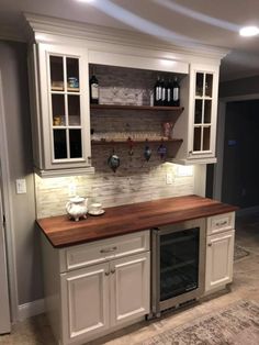 a kitchen with white cabinets and wood counter tops, an oven in the center is built into the wall