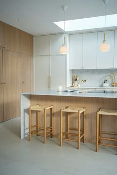 three stools are in front of the kitchen counter