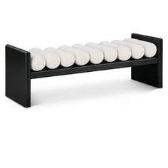 a black bench with white cushions on it