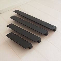 four black handles on a white counter top