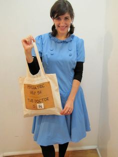 a woman in a blue dress is holding a bag that says, the doctor is n