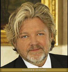 a close up of a person wearing a suit and tie with a gold frame around his neck