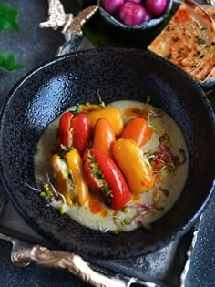 a bowl filled with vegetables and sauce on top of a table next to other foods