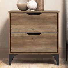 a wooden dresser with two drawers and vases on top