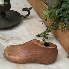 a potted plant sitting on top of a table next to a wooden shoe shaped planter