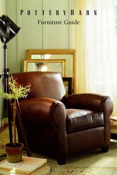 a brown leather chair sitting on top of a rug next to a lamp and mirror