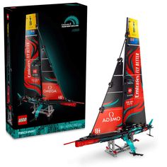 a red and black model sailboat in front of a box