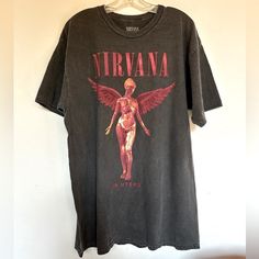 a t - shirt hanging on a wall with the word nirvana printed on it and an image of a human being