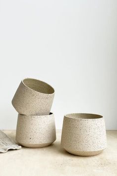 three cement bowls sitting on top of a table next to a towel and cup holder