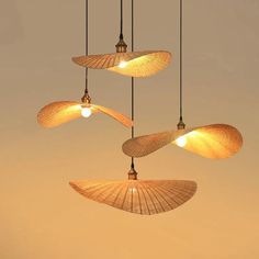 three lamps hanging from the ceiling in front of a beige sky