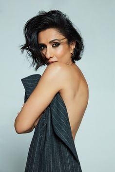 an image of a woman with short hair wearing a black and white striped dress posing for the camera