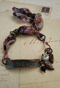 a bracelet with an i am the story charm attached to it, on top of a piece of paper