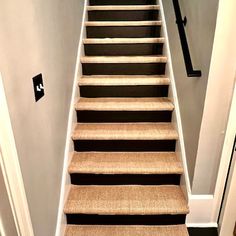 the stairs are lined with black and white carpet