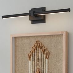 a wall mounted light with rope on the bottom and an embroidered curtain hanging from it's side