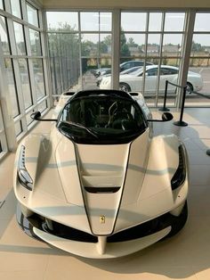 a white sports car is parked in a showroom