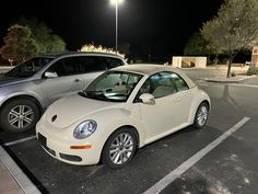 two cars parked in a parking lot at night