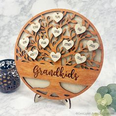 a wooden family tree with hearts on it and the word grandkids written in cursive writing