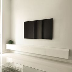 a white room with a large flat screen tv on the wall