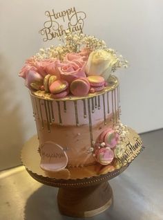 a birthday cake decorated with flowers and macaroons