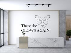 there she glows again wall decal in an office with marble counter and plant