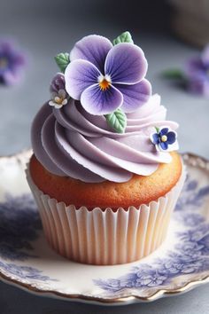 a cupcake with frosting and purple flowers on it