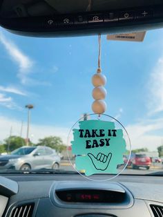 a car dashboard with a sign that says take it easy hanging from the dash board