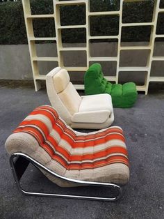 an orange and white striped chaise lounge chair next to a green teddy bear