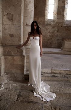 a woman in a white dress standing on some steps