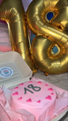 pink and gold birthday cake with balloons in the shape of 80 on it's side