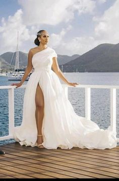 a woman in a white dress standing on a deck