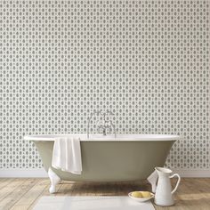 an old fashioned bathtub in front of a wallpapered bathroom with a white rug