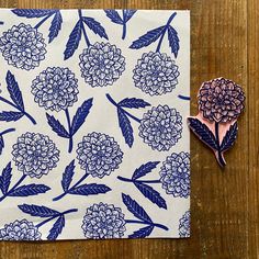 a blue and white flower pattern on a piece of paper next to a pair of scissors