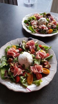 two plates filled with salad on top of a table