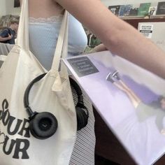 a woman carrying a bag with headphones on it