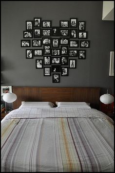 a bed sitting in a bedroom next to a wall with pictures on it