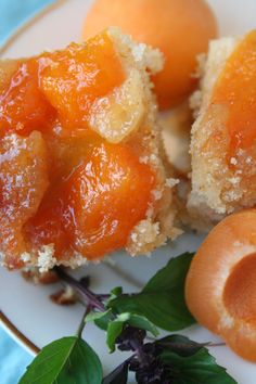 some oranges are sitting on a plate with powdered sugar and green leafy leaves