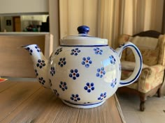 a blue and white tea pot sitting on top of a wooden table