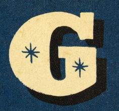 the letter g is written in black and white on a blue background with small stars