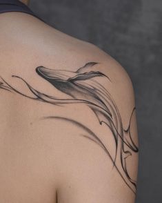 the back of a woman's shoulder with a tattoo on it